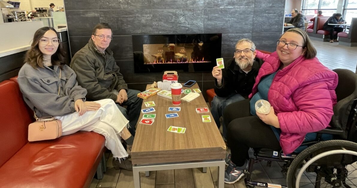 Un groupe de quatre personnes jouant aux cartes dans un café local.