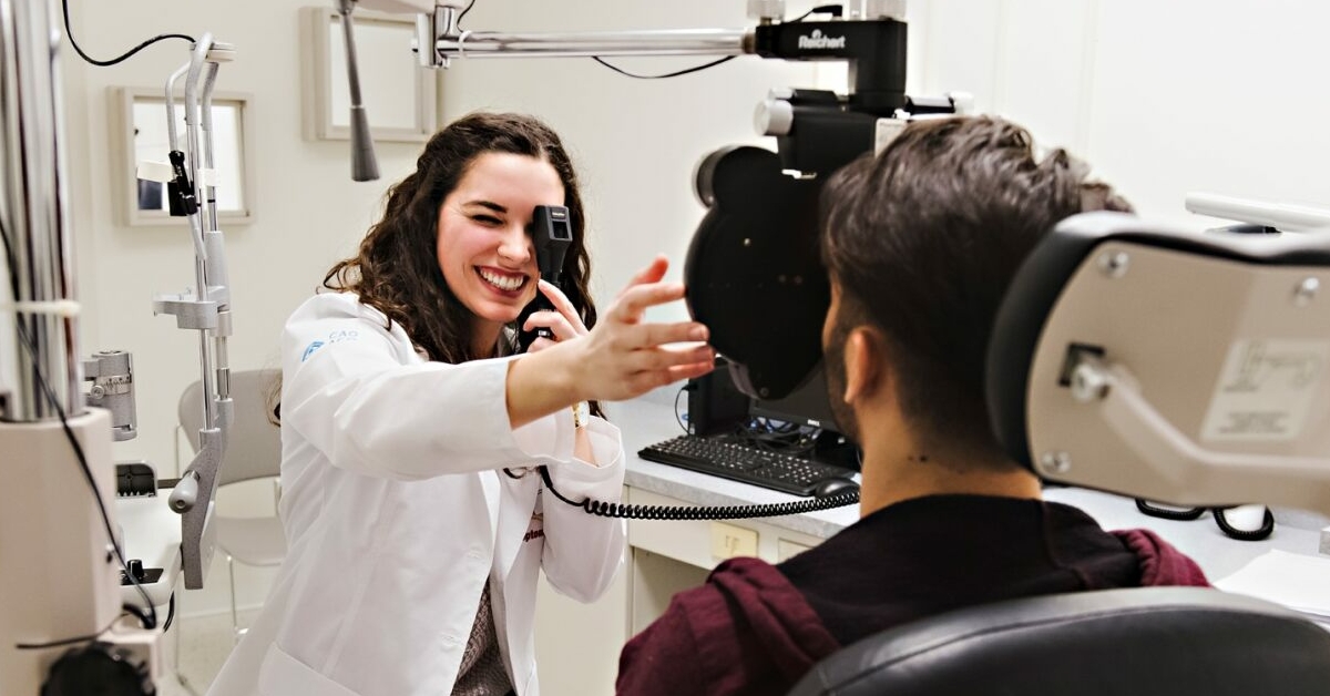 Un optométriste utilise ses outils pour vérifier les yeux d'un patient.