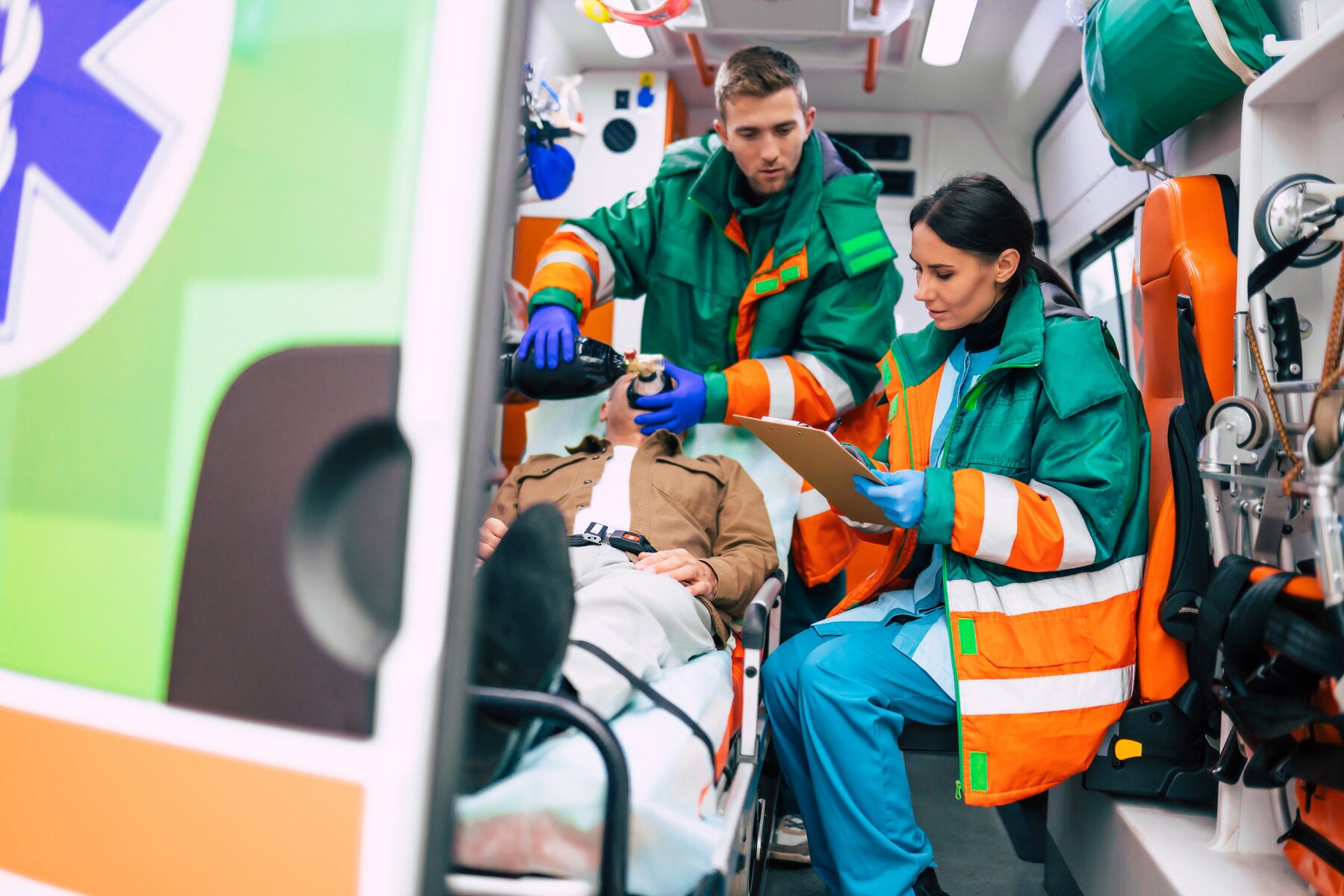 Deux urgentistes à l’arrière d’une ambulance avec un patient.