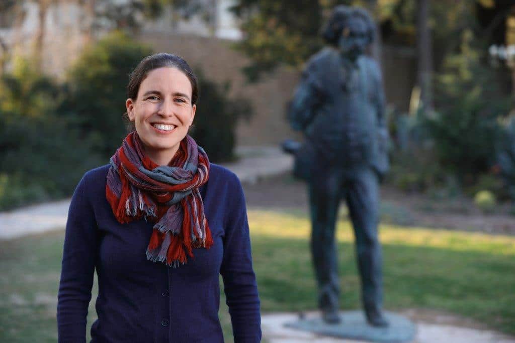 Mor Nitzan, an Azrieli Graduate Studies Fellow, poses with a statue of Albert Einstein. 