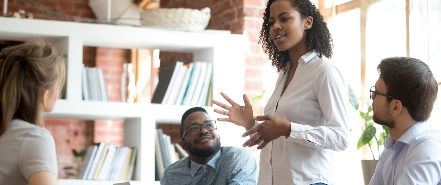 Ambitious african black female employee speaking at diverse meeting