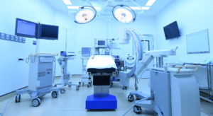 An operating room table with lights, screens and other hospital equipment.