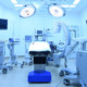 An operating room table with lights, screens and other hospital equipment.