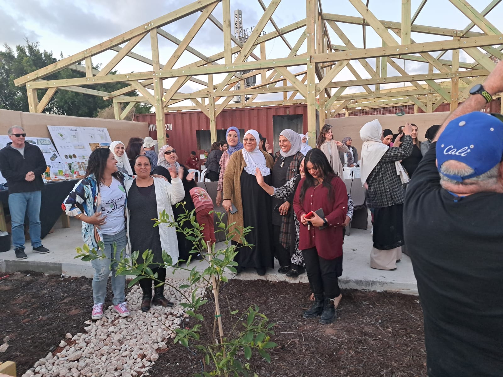 People gathered in front of a partially built outdoor structure.