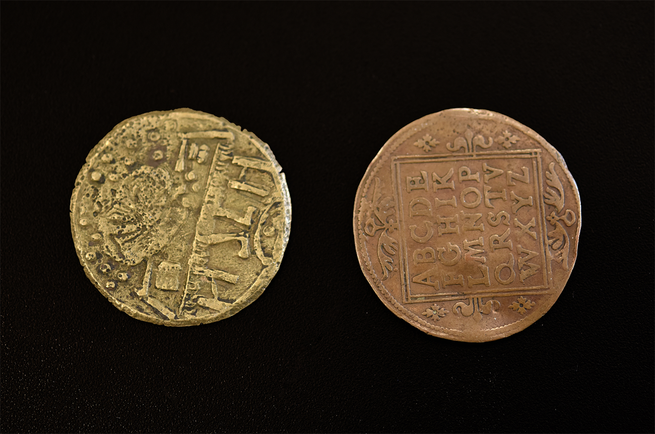 A gold coin and a bronze coin on a black background.
