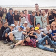 A large group of preteens smiling and posing for the camera.