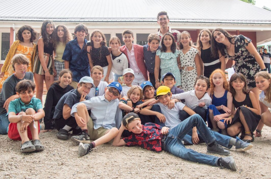A large group of preteens smiling and posing for the camera.