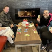 A group of four people playing a game of cards at a local coffee shop.